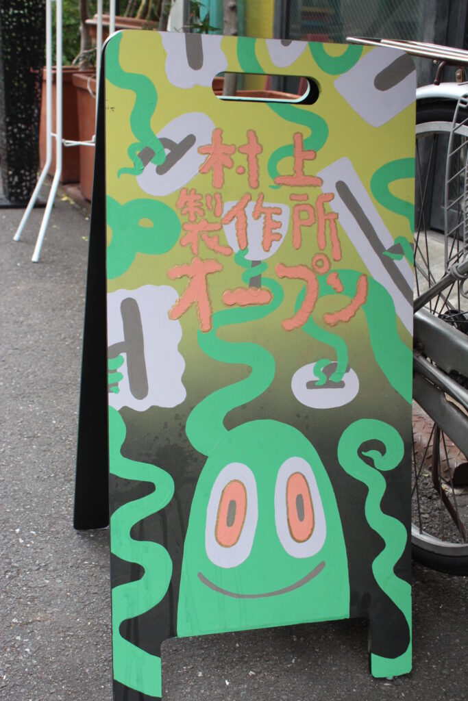「村上製作所オープン」と書かれたカラフルな立て看板