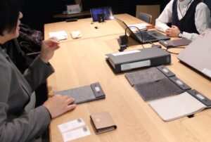生地サンプルを机に広げ、やり取りする人たち