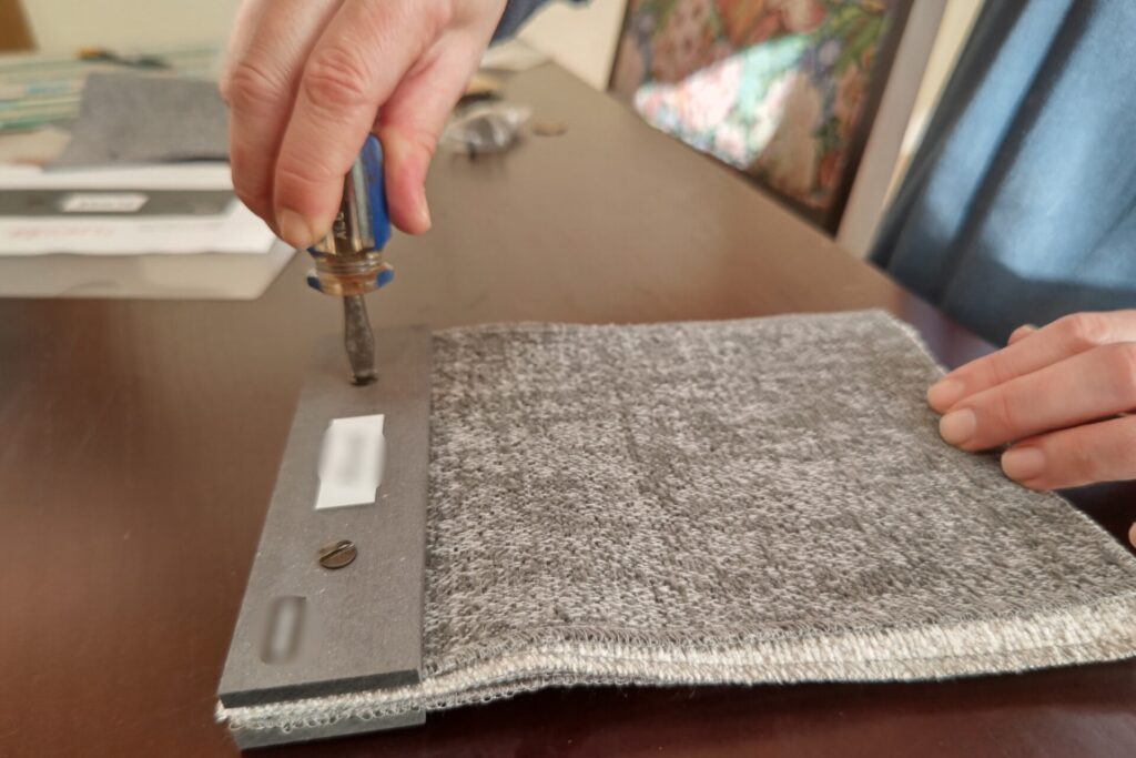 複数のオフィスチェアのサンプル生地をビスでまとめる作業